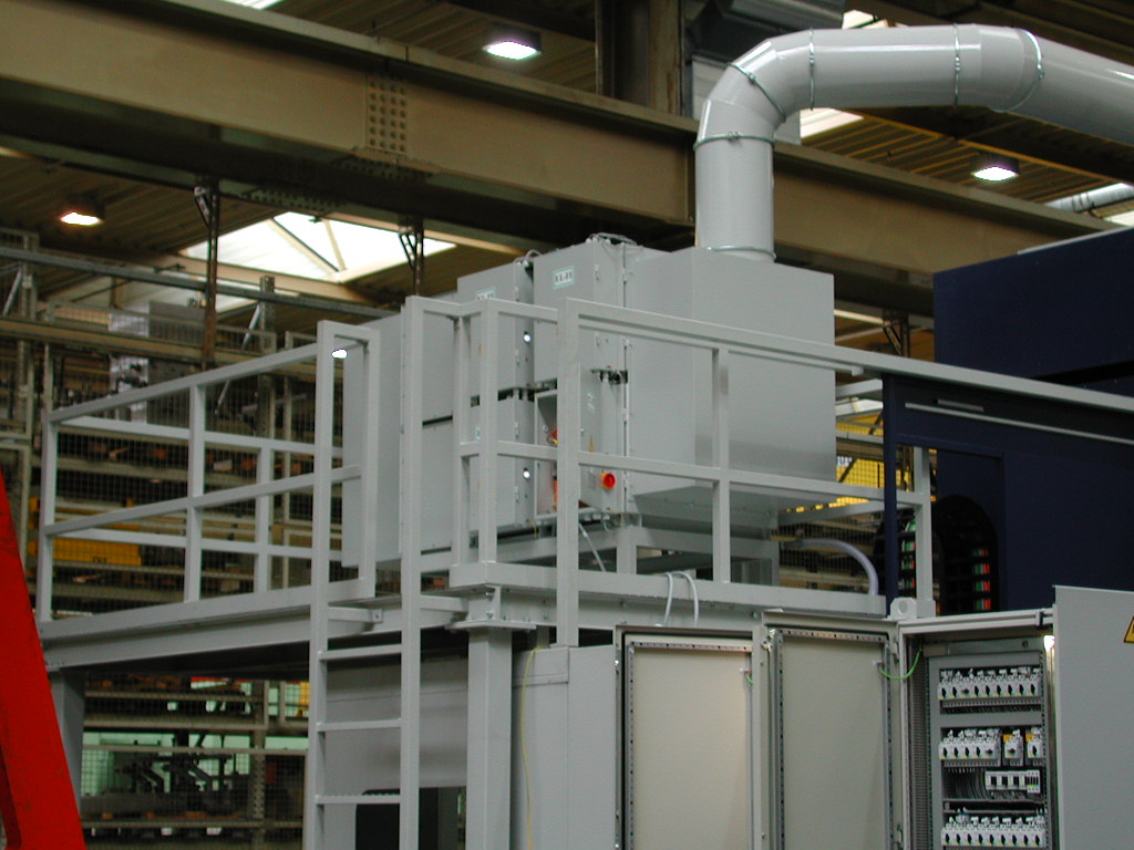 Industrieanlage mit verschiedenen Maschinen und Rohrleitungen in einer Fertigungshalle.